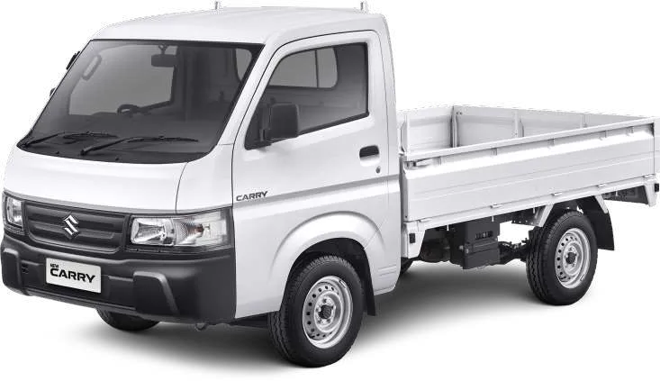 Tampilan eksterior depan samping truk pikap Suzuki Carry putih yang diparkir di luar ruangan.