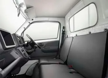 Interior kabin Suzuki Carry pick-up, menampilkan dashboard, setir, dan jok pengemudi yang fungsional.