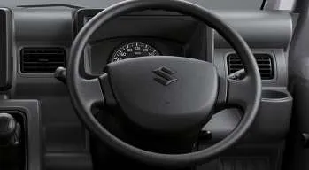 Interior kabin Suzuki Carry pick-up, menampilkan dashboard, setir, tuas transmisi, dan jok pengemudi yang fungsional.